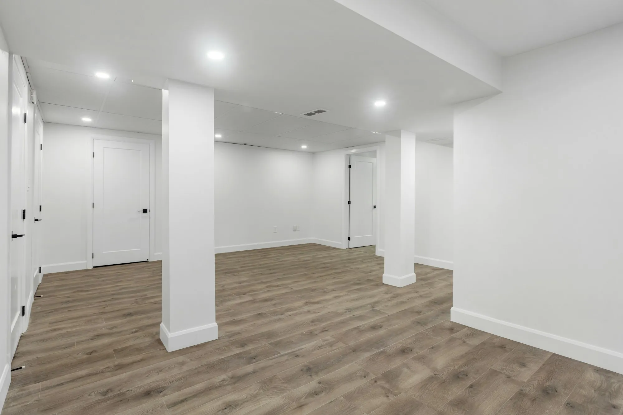 Finished basement with a family room, recessed lighting and a guest bedroom door